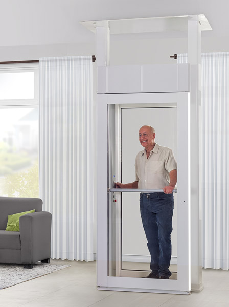 Elderly man using the Savaria Luma through-floor lift beside a living room