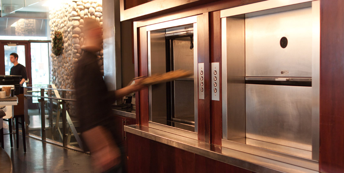 Man placing boxes into a Matot material lift / dumbwaiter